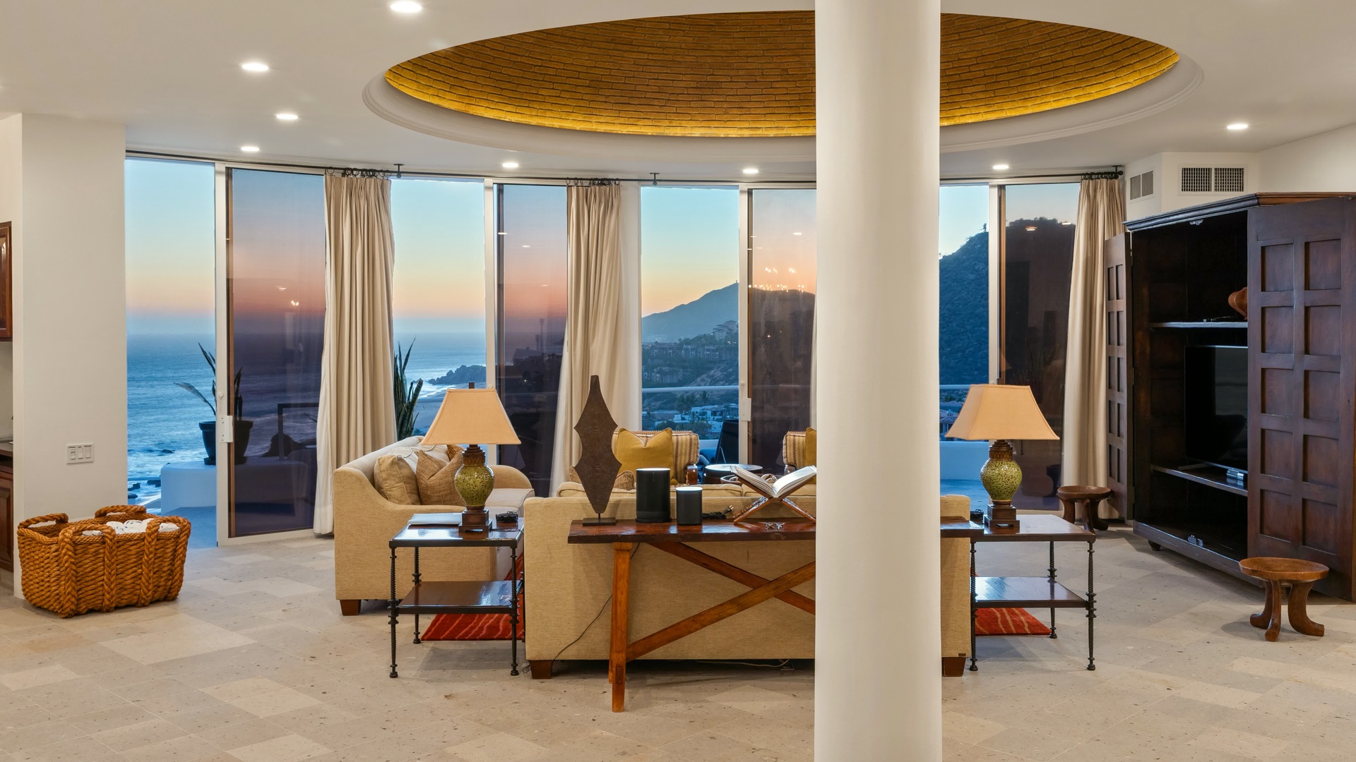 Unwind in your elegant living space where floor-to-ceiling windows frame breathtaking ocean and mountain vistas, creating the perfect backdrop for relaxation.