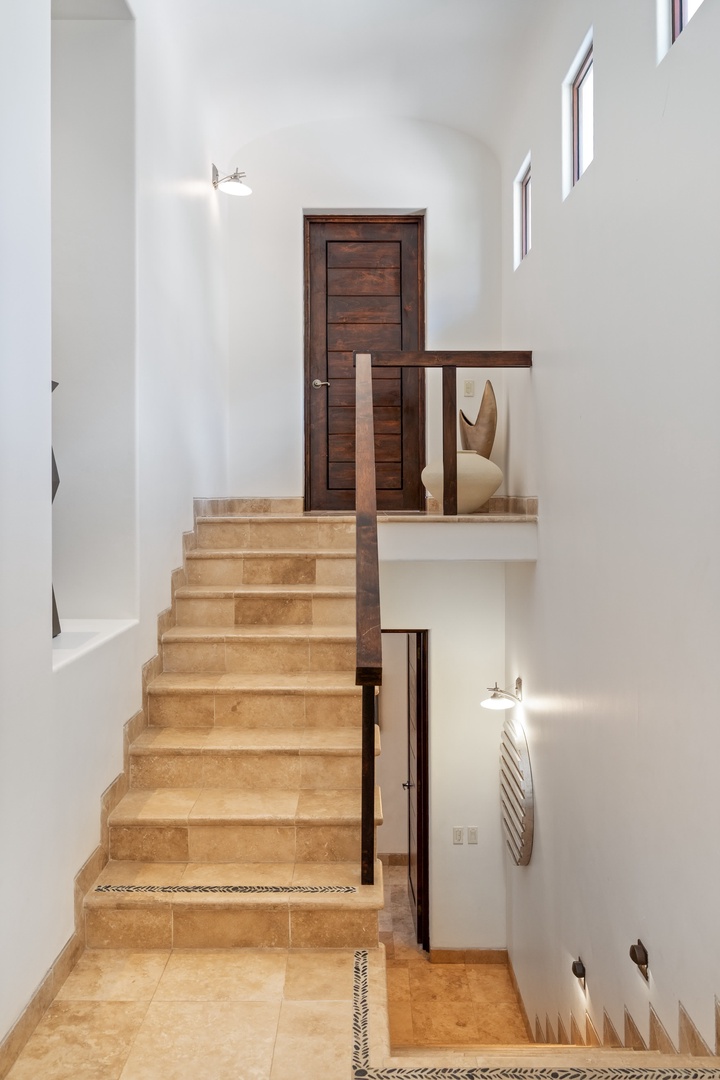 Step into your private sanctuary featuring elegant stone stairs and rich wood details that create a sophisticated multi-level retreat.