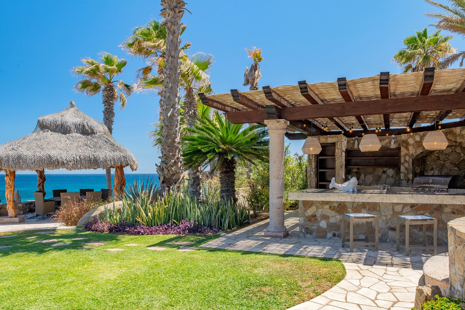 Step into your private tropical paradise with stunning ocean views, lush gardens, and an inviting outdoor kitchen perfect for seaside dining.