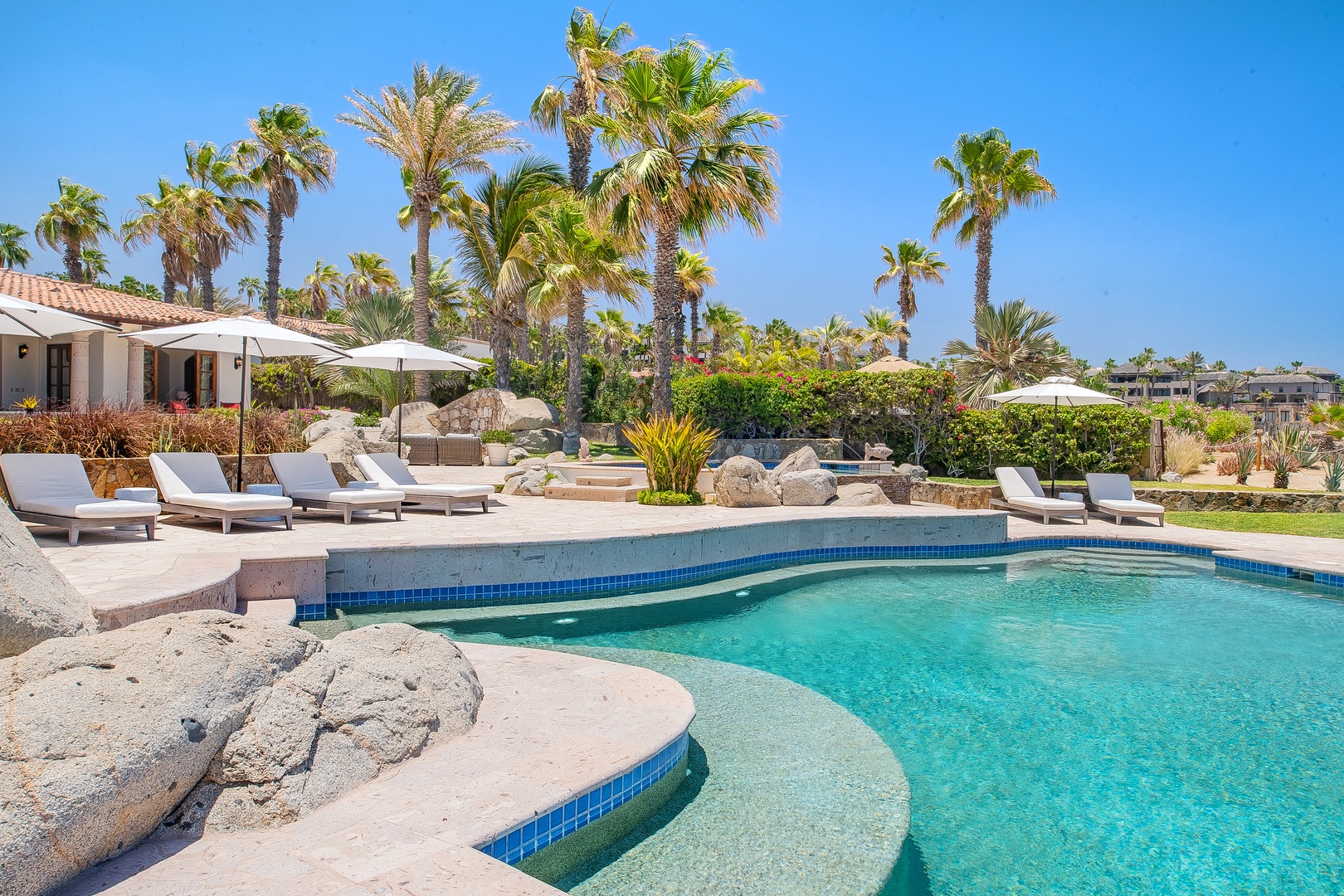 Dive into your private oasis with crystal-clear turquoise waters, surrounded by swaying palms and comfortable loungers for ultimate relaxation.