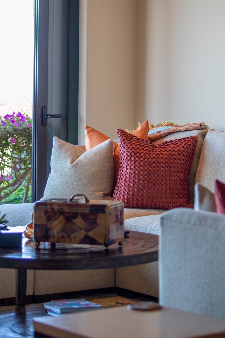 Sink into plush cushions and vibrant textures, where warm sunlight and garden views create your perfect spot to unwind and recharge.