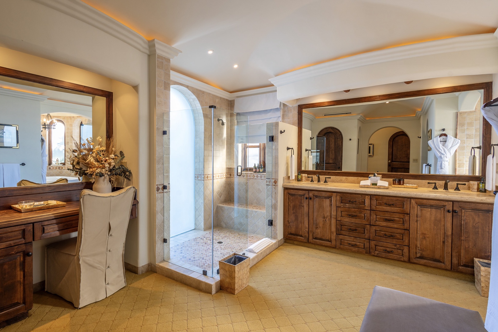Step into your private sanctuary, where rich wood cabinetry and elegant stonework create a spa-like atmosphere. Enjoy your spacious walk-in shower and dual vanities, plus a cozy seating area—everything designed for your ultimate comfort and relaxation.