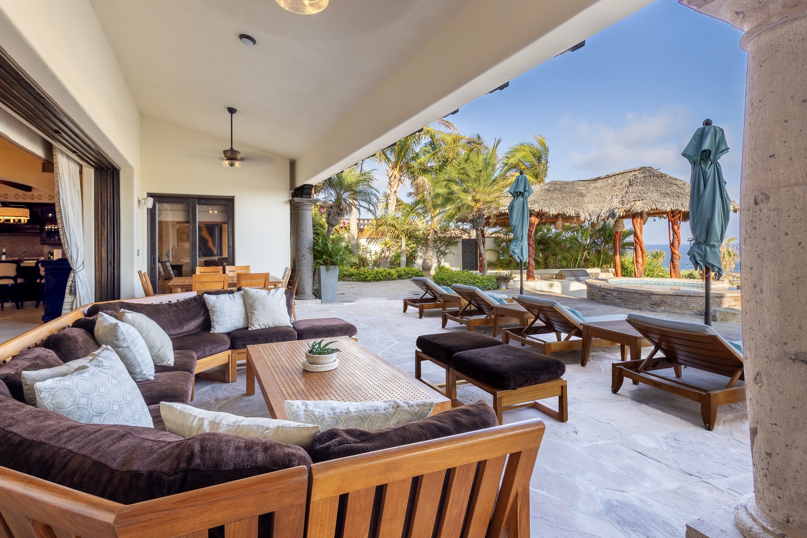 Step into your private tropical oasis where plush loungers and an inviting open-air living area seamlessly blend indoor comfort with the island breeze and swaying palms just beyond.