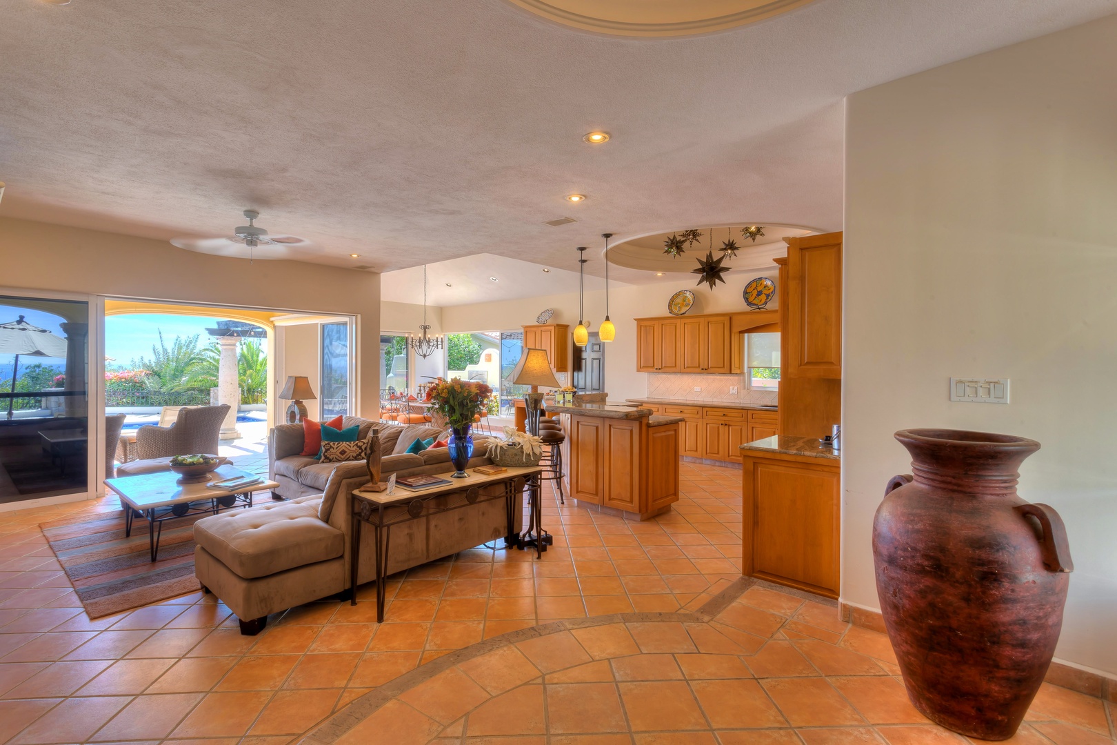 Relax in your spacious open-plan living area where warm terracotta tiles and rich wood cabinetry create the perfect desert retreat atmosphere.