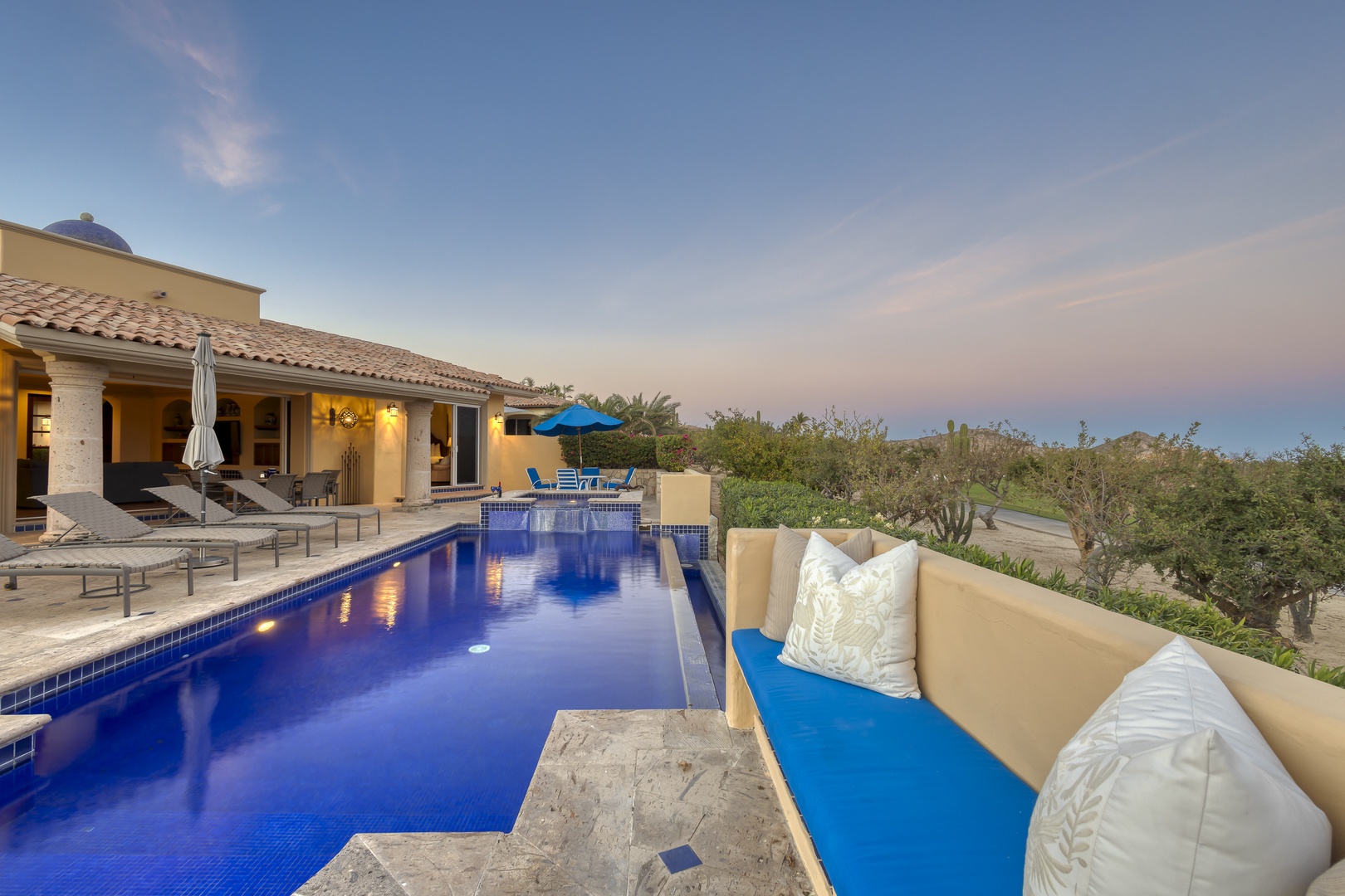 Unwind in your private oasis with stunning pool views and plush outdoor seating as twilight paints the sky.