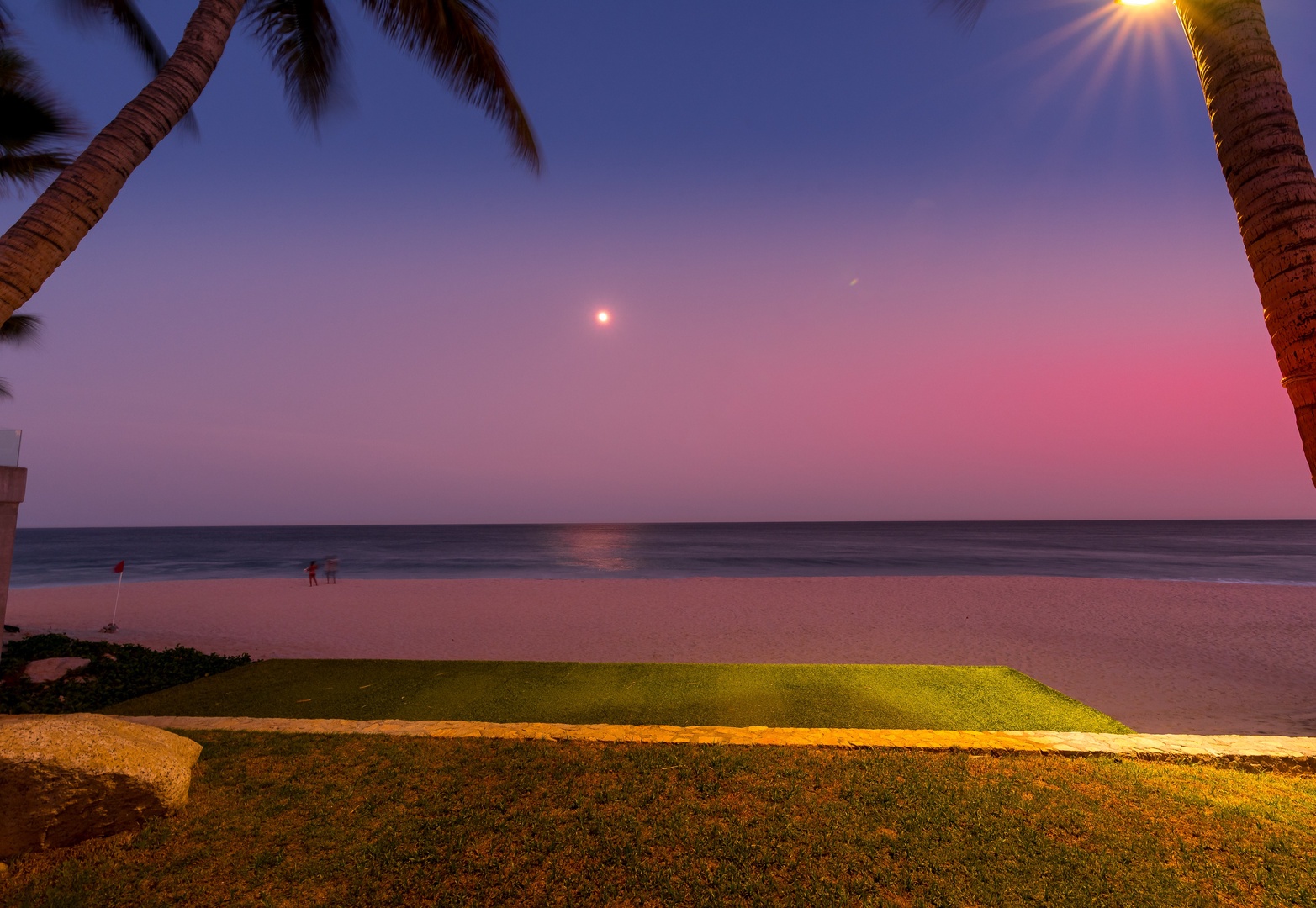 A stunning oceanfront location framed by palm trees, just steps from soft sands and tranquil waters. Sunsets paint the sky with vibrant hues.