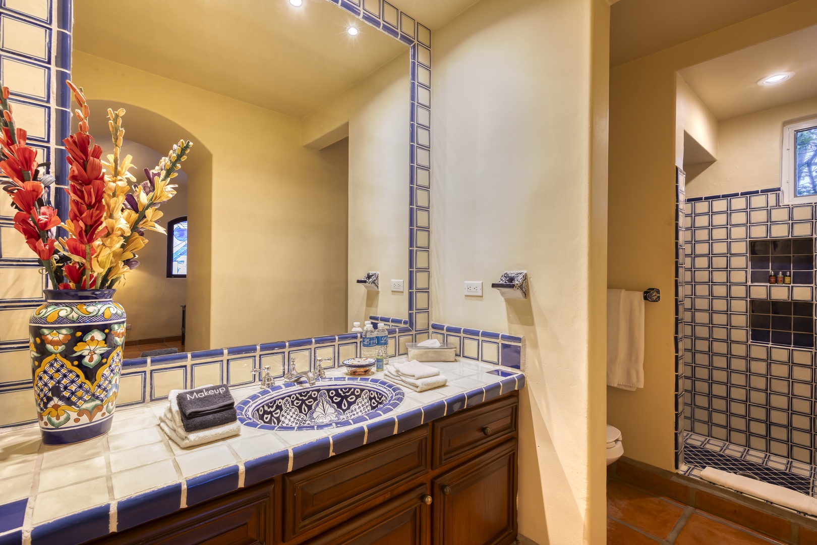 Immerse yourself in this stunning Mexican-inspired bathroom featuring handcrafted Talavera tiles, an artisan sink, and luxurious walk-in shower.