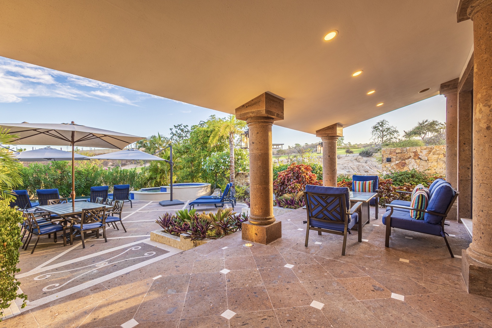 Your private covered patio offers plenty of seating for relaxing and dining, with lush garden views and pool access just steps away.