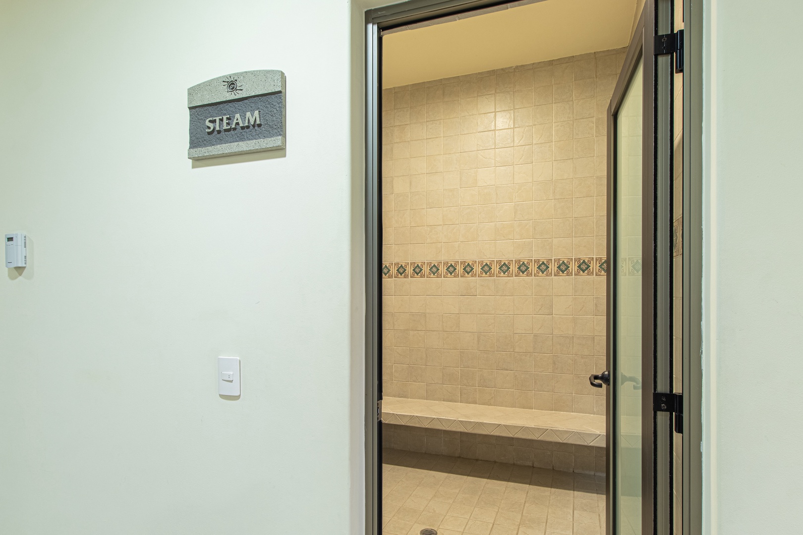 The property features a private steam room with elegant tile work and a built-in bench, providing a soothing escape after a day of exploration.