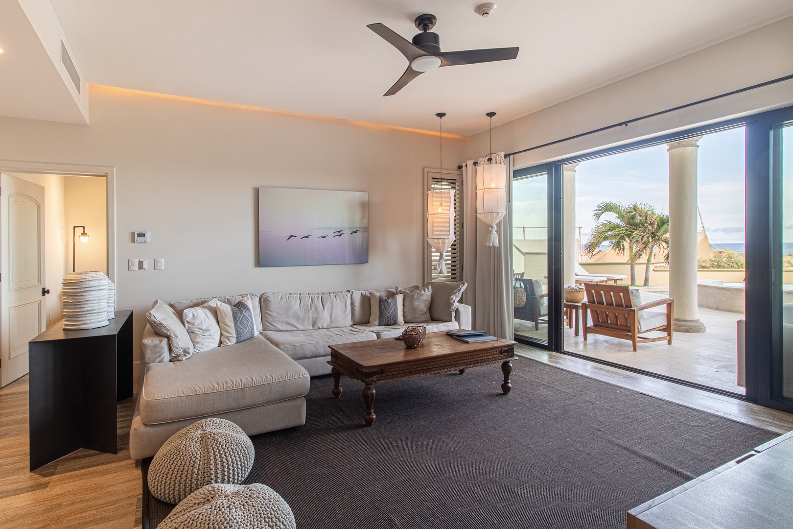 Your serene living room opens to a private terrace where ocean breezes and views of swaying palms await, perfect for unwinding after beach days.