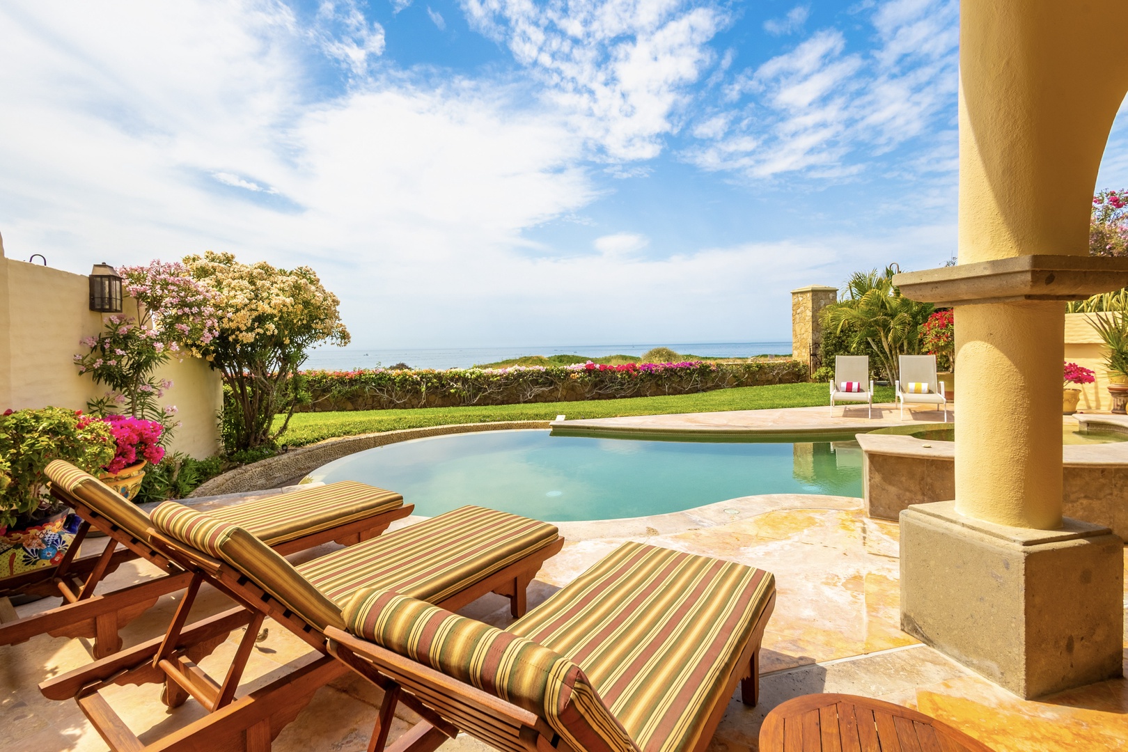 Relax on your private terrace beside the sparkling pool, where vibrant tropical gardens meet endless ocean views. Soak in the sun on plush loungers, perfect for unwinding in paradise.