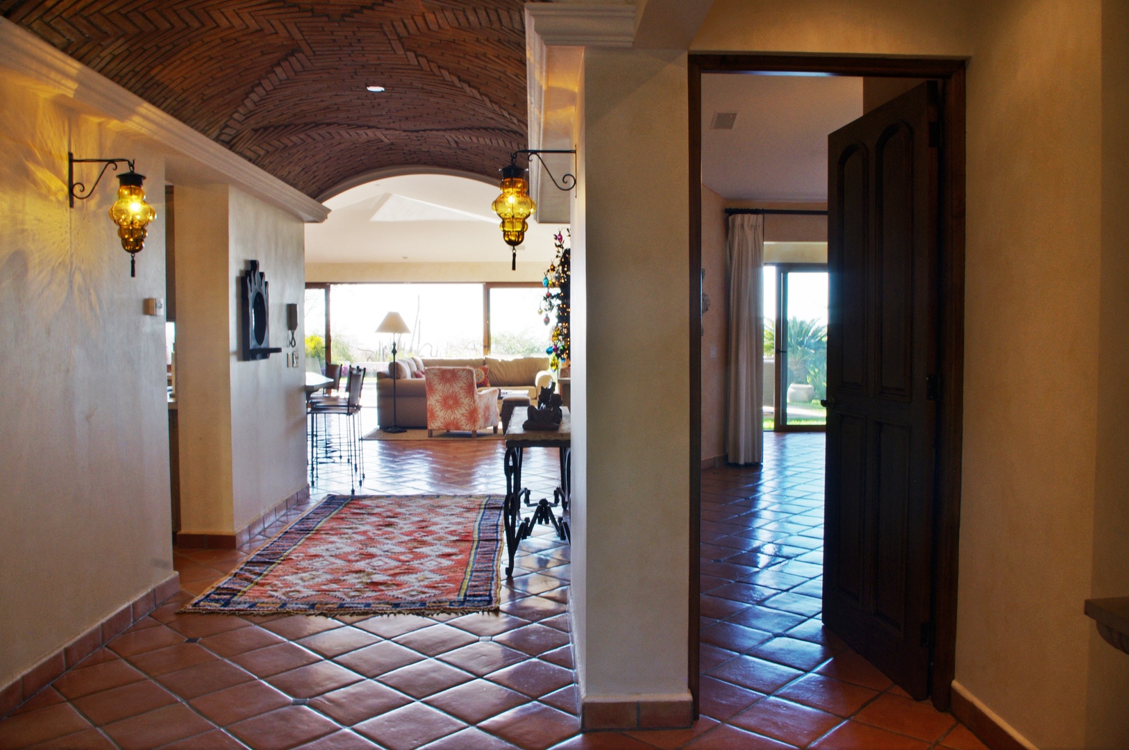 Arched brick ceilings and terracotta tiles welcome you into a sun-drenched villa where Moroccan lanterns glow and open doorways reveal peaceful garden views beyond.
