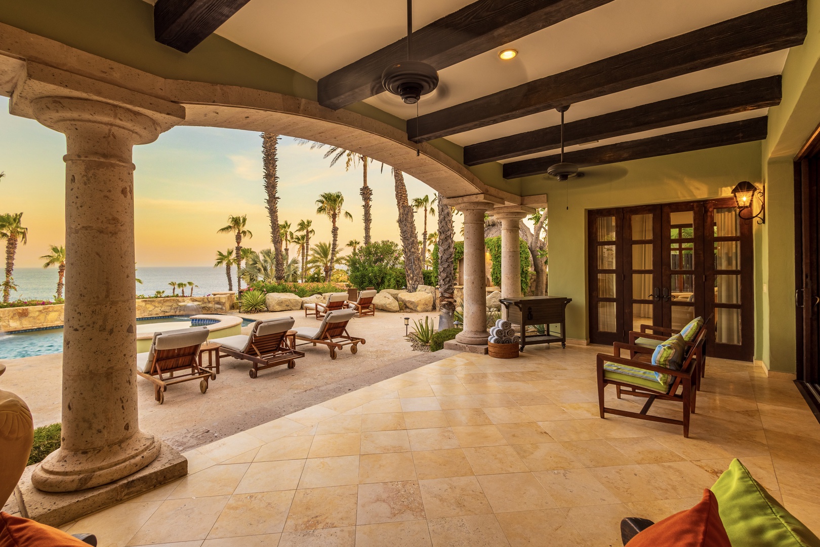 Your private covered terrace opens to tropical gardens, a sparkling pool, and ocean views framed by swaying palms—the perfect spot to unwind with a sunset drink.