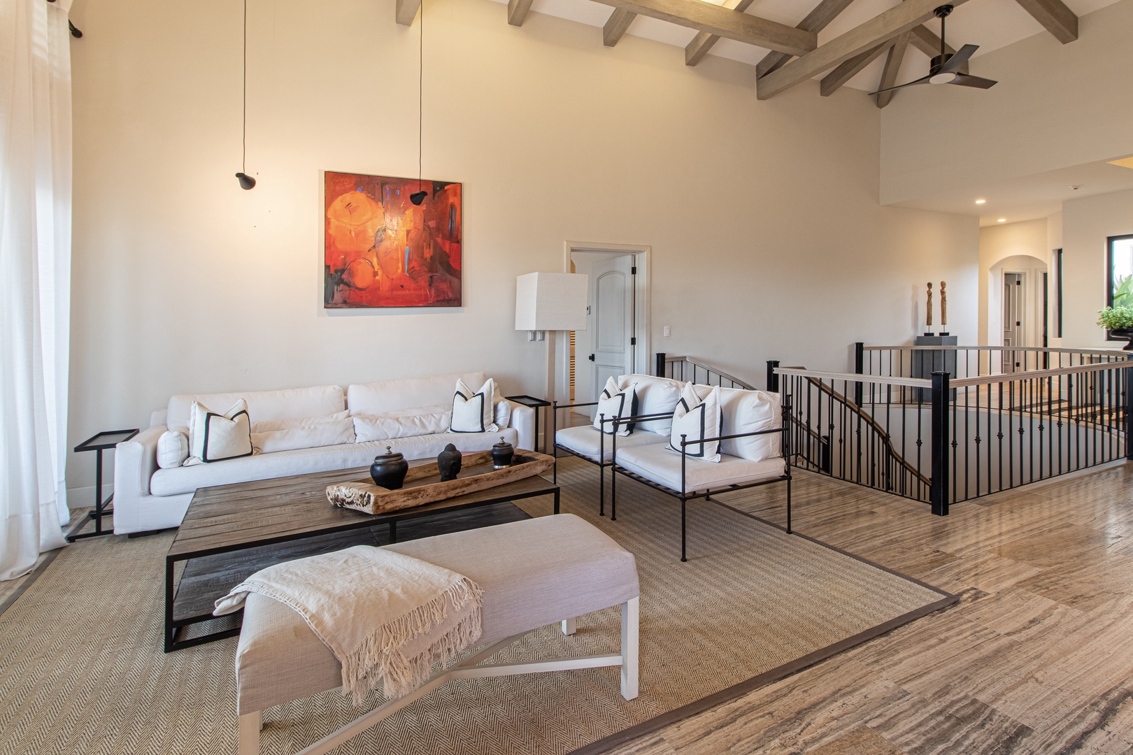 Settle into your inviting living room, where soaring exposed beam ceilings and warm wood floors create an airy, sophisticated retreat for relaxing with loved ones.