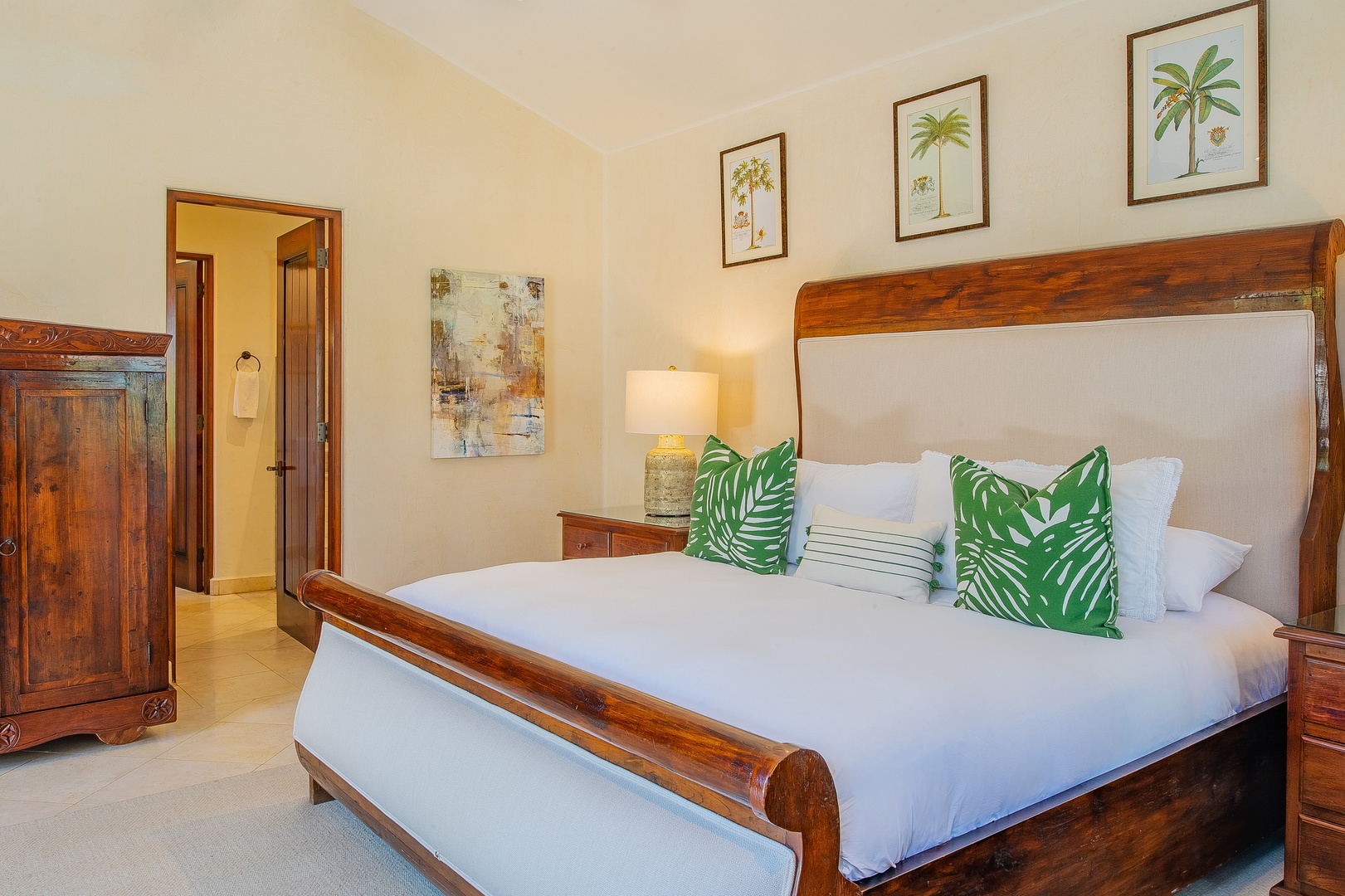 Drift off in your tropical-themed bedroom with rich wood furniture, crisp linens, and cheerful palm leaf accents creating a resort-like retreat.