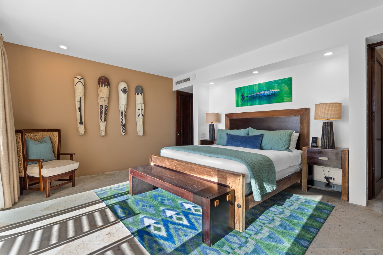 Sink into your serene retreat featuring rich wood furnishings, ocean-inspired artwork, and plush bedding that promises restful nights in tropical luxury.