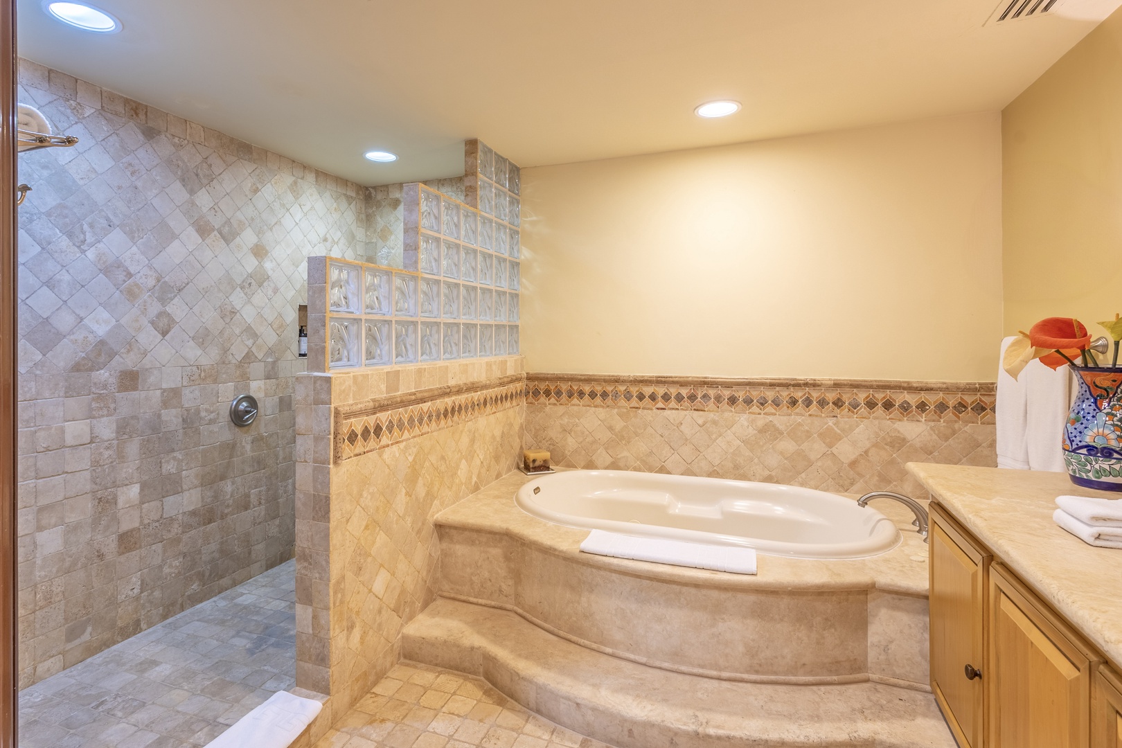 Unwind in your spa-inspired bathroom featuring a luxurious soaking tub and spacious walk-in shower with elegant tile work throughout.