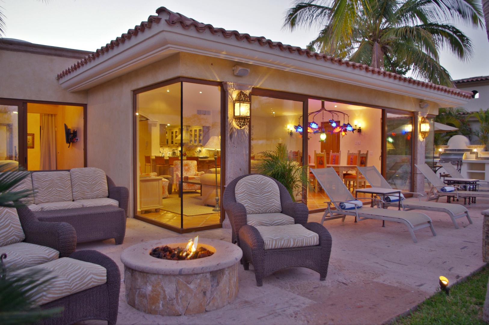 Unwind on your private patio with a crackling fire pit, plush seating, and warm evening glow spilling from your open-plan living and dining area.