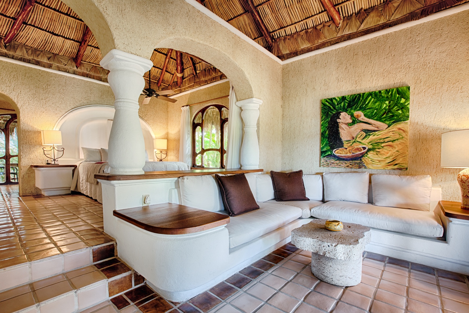 Unwind in your elegant living space with soaring palapa ceilings, plush sectional seating, and authentic Mexican artistry that creates a serene tropical retreat.
