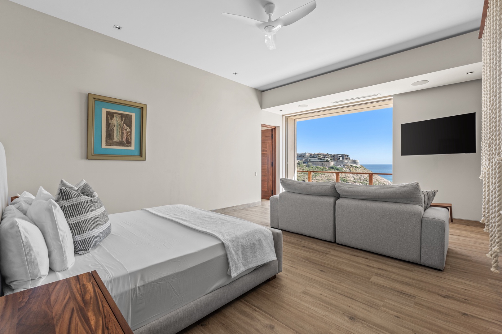 Your spacious suite opens to sweeping coastal views through wall-to-wall windows. Wake to ocean breezes beneath the ceiling fan, then unwind on the plush sofa while taking in the sea.