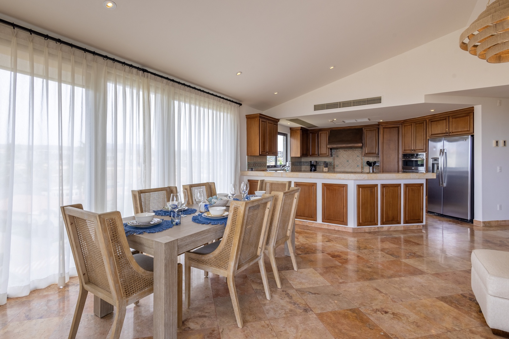 Gather around your elegant dining table where warm wood tones and gleaming marble floors create the perfect setting for memorable meals together.
