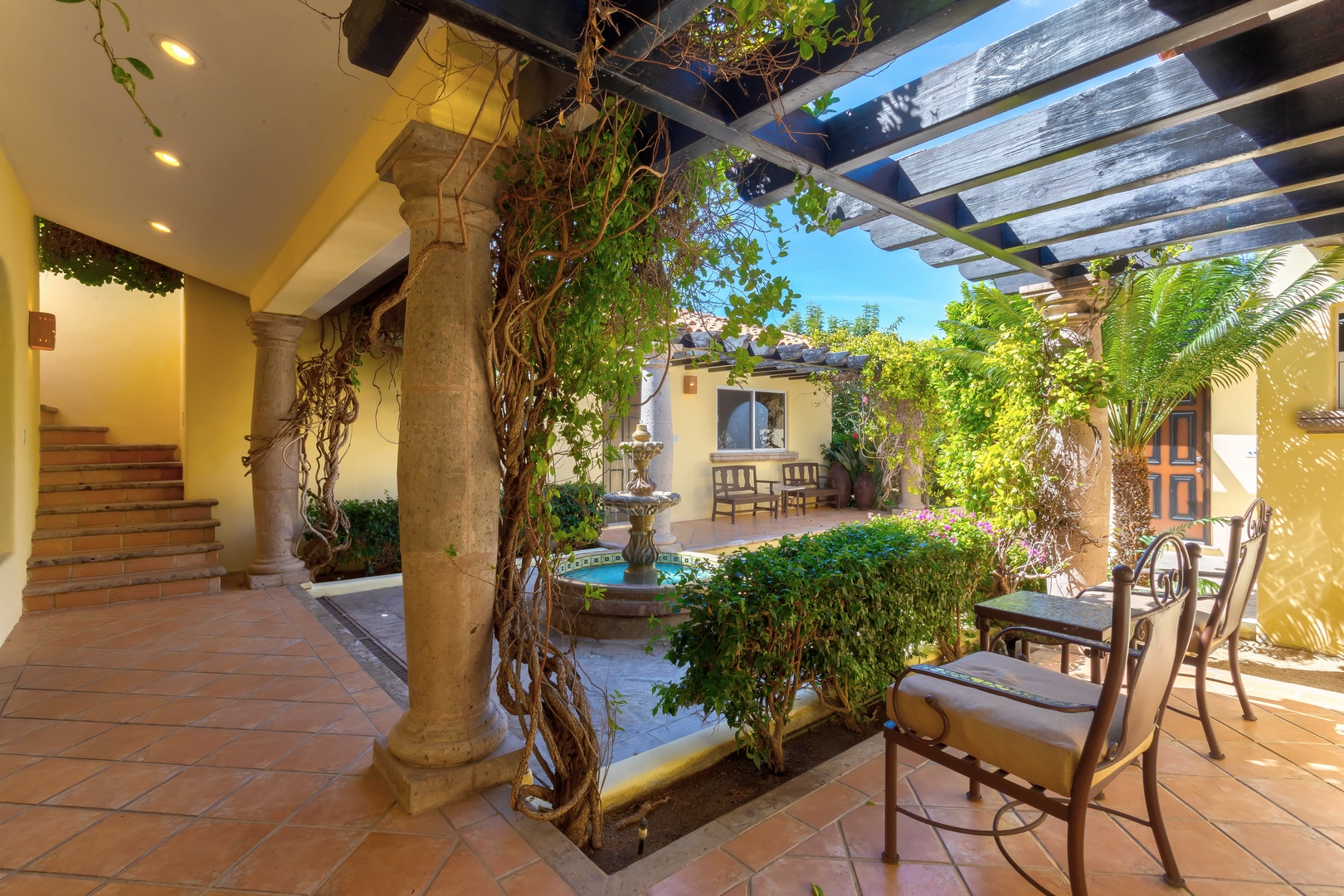Unwind in your private courtyard oasis, where stone columns and lush greenery create the perfect retreat for morning coffee or evening relaxation.