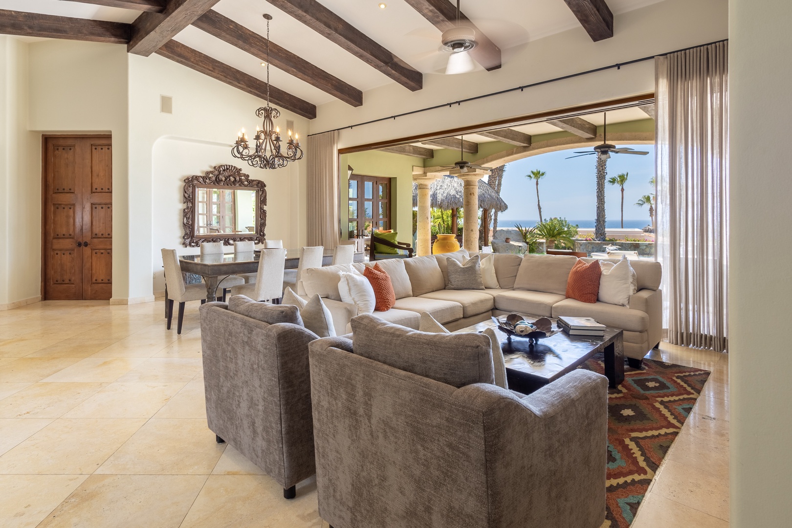 Relax in your elegant living space where rustic beams meet coastal luxury, and ocean views beckon through expansive windows.