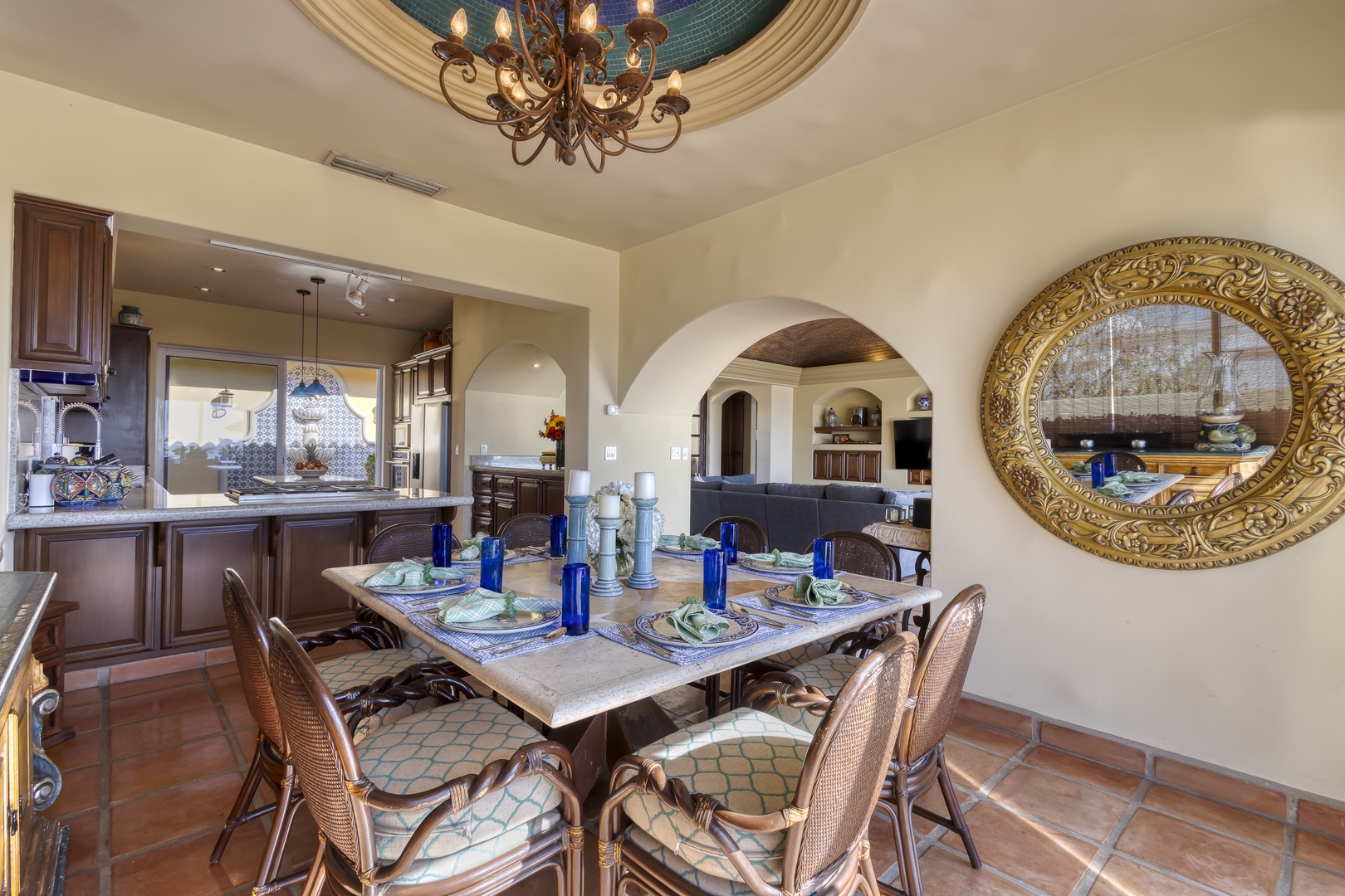Gather around this elegant dining table where Mediterranean charm meets luxury - the arched ceiling and ornate chandelier create an enchanting atmosphere for your memorable meals.