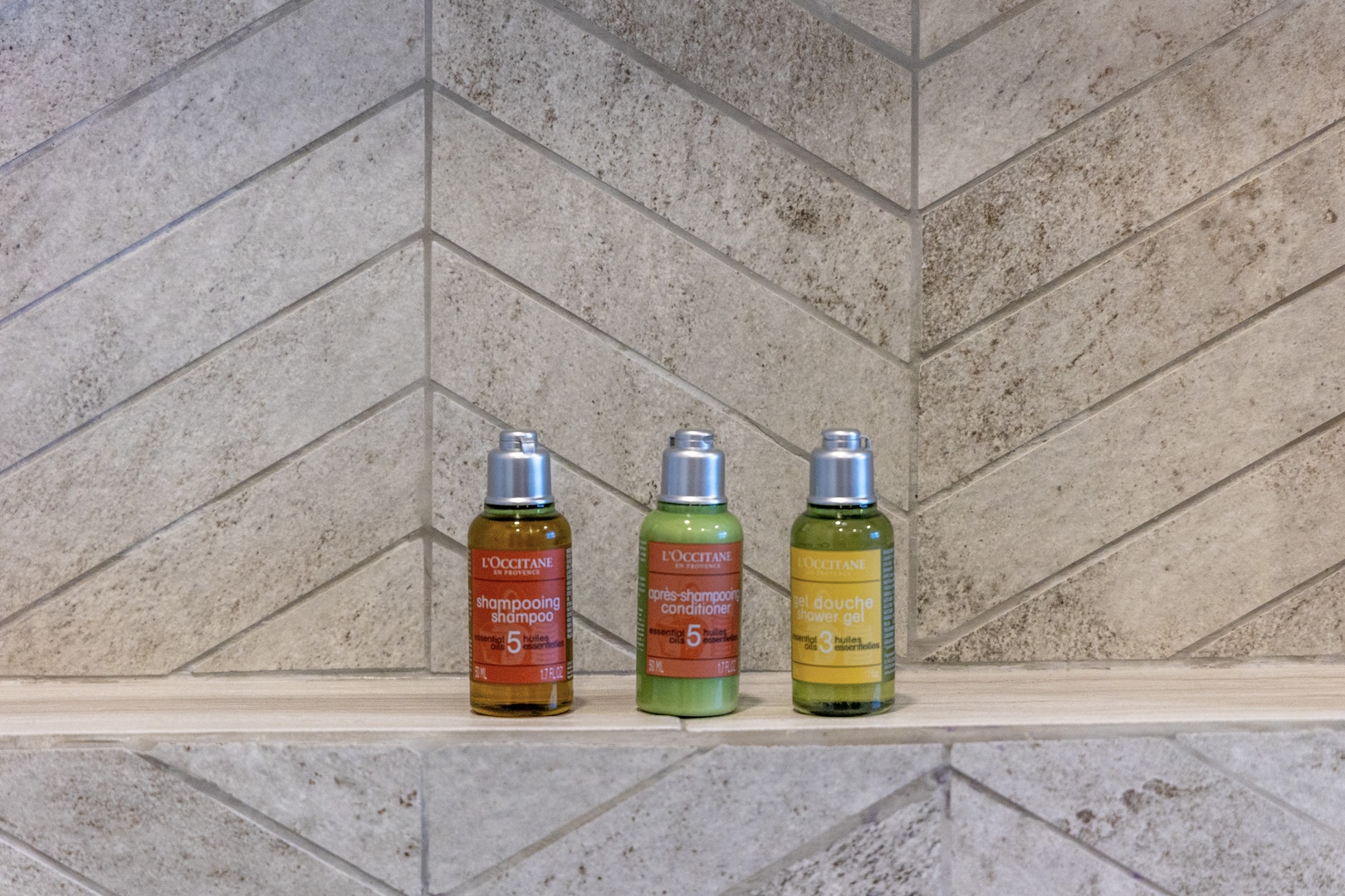 Premium toiletries await your arrival, displayed on elegant herringbone tile—a thoughtful touch to make your stay feel special and refreshing.