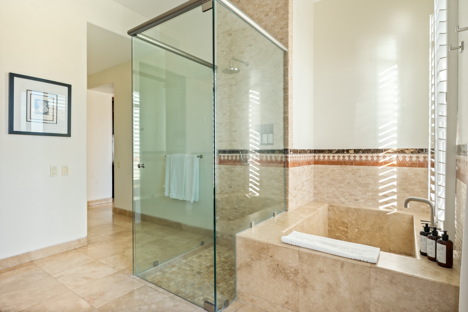 Unwind in your elegant marble bathroom with glass-enclosed shower and deep soaking tub, perfect for relaxing after your adventures.