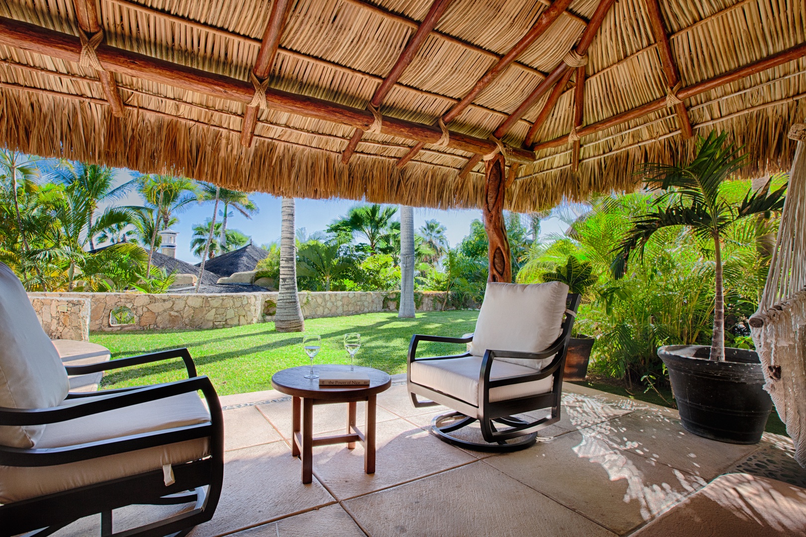 Relax in your private thatched-roof gazebo, where tropical breezes flow through open sides while you unwind with garden views.