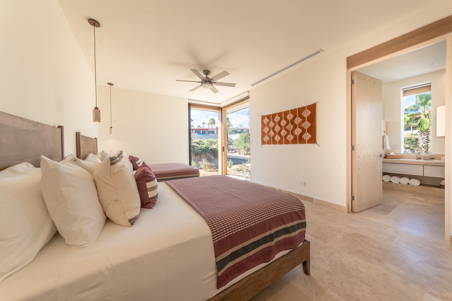 Relax in your serene bedroom with two plush beds, warm desert tones, and an en-suite bathroom—perfect for unwinding after your desert adventures.