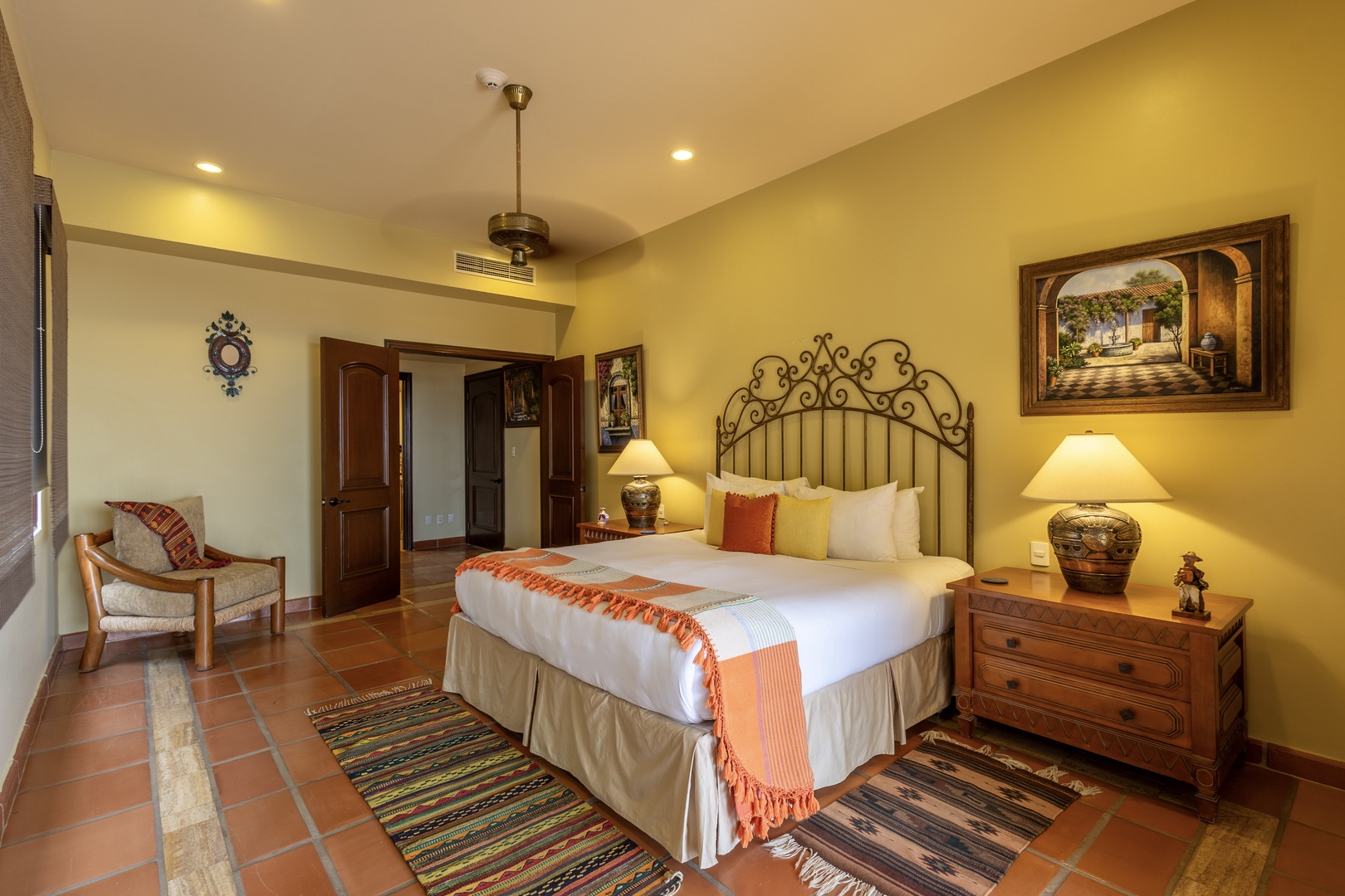 Step into your warm, sun-filled retreat with rustic elegance. Sink into crisp linens beneath a handcrafted iron headboard, while soft ceiling fans keep you cool in your charming terracotta-tiled sanctuary.