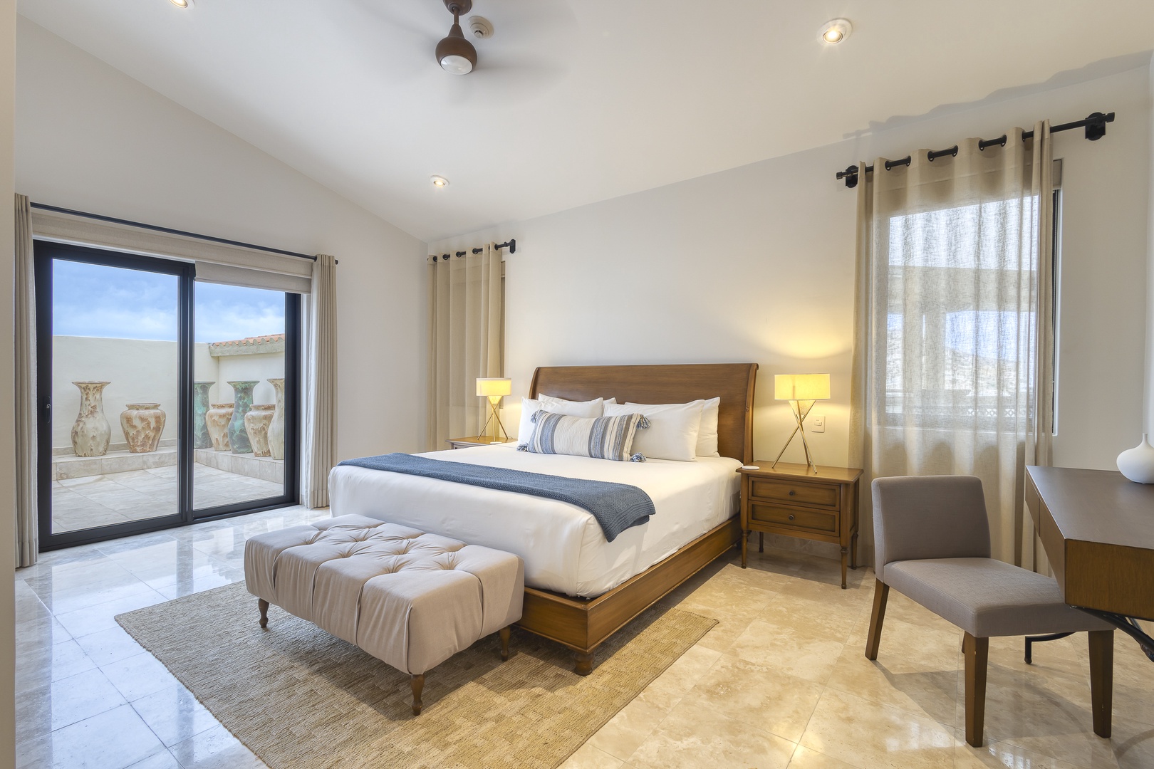 Your bright, serene bedroom features a plush king bed, elegant furnishings, and direct access to your private terrace. Sink into comfort as natural light fills the space.