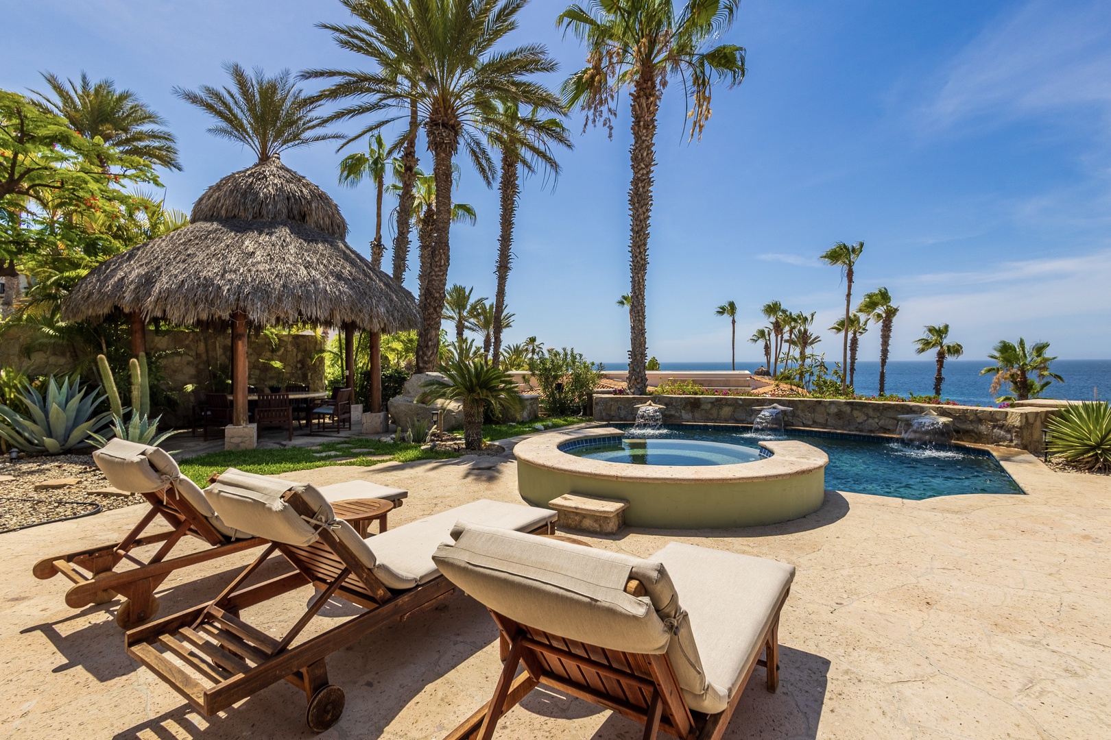 Stretch out on your private lounger and soak in the stunning oceanfront setting, where a sparkling pool and hot tub await just steps from swaying palms and endless blue waters.