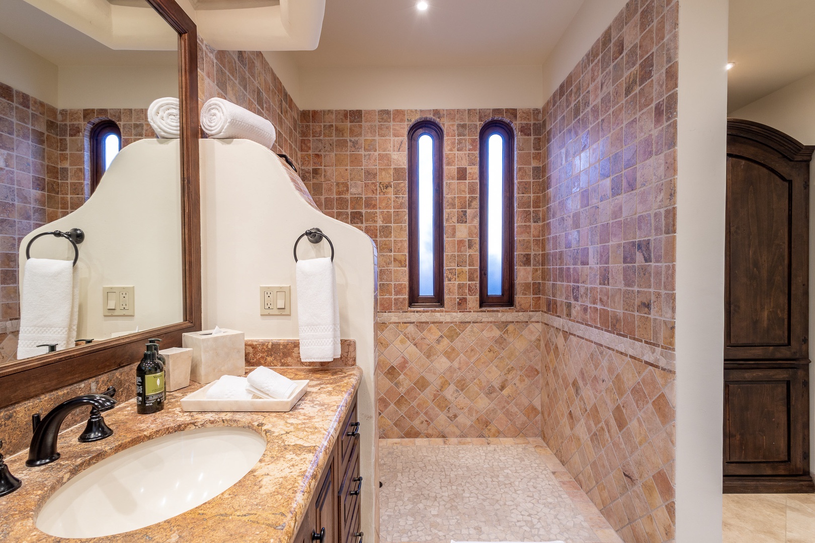 Your spa-inspired bathroom features warm terracotta tile, a luxurious walk-in shower, and elegant fixtures—perfect for unwinding after a day of adventure.