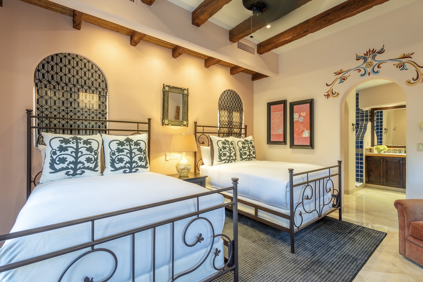 You'll love the artisan details here—rustic beams, handcrafted ironwork, and patterned alcoves that bring character to your stay. Sink into plush beds beneath warm lighting, with your private bathroom just steps away.