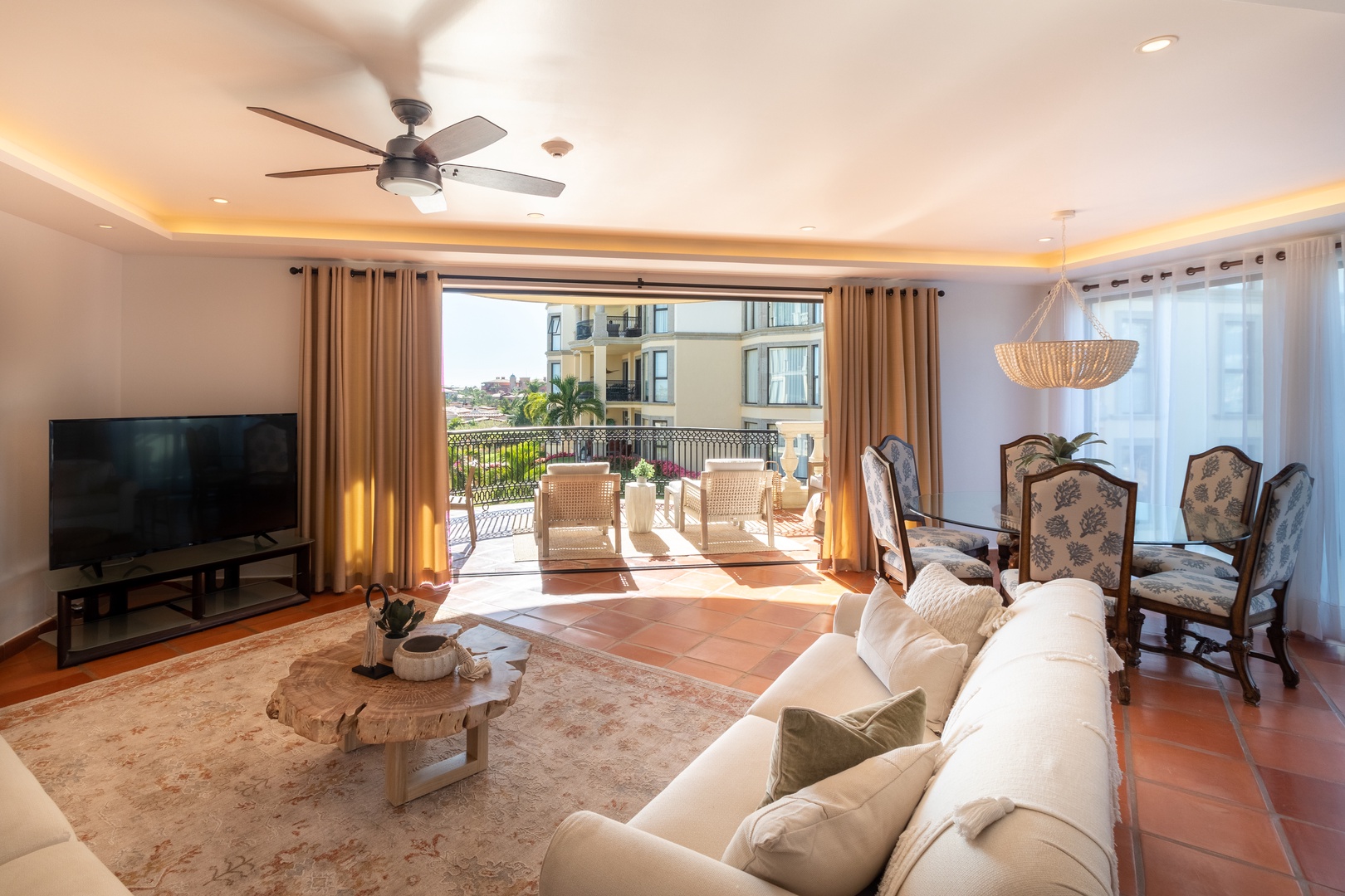 Relax in your bright, spacious living area with stylish coastal décor, plush seating, and direct terrace access where warm breezes and peaceful views await.