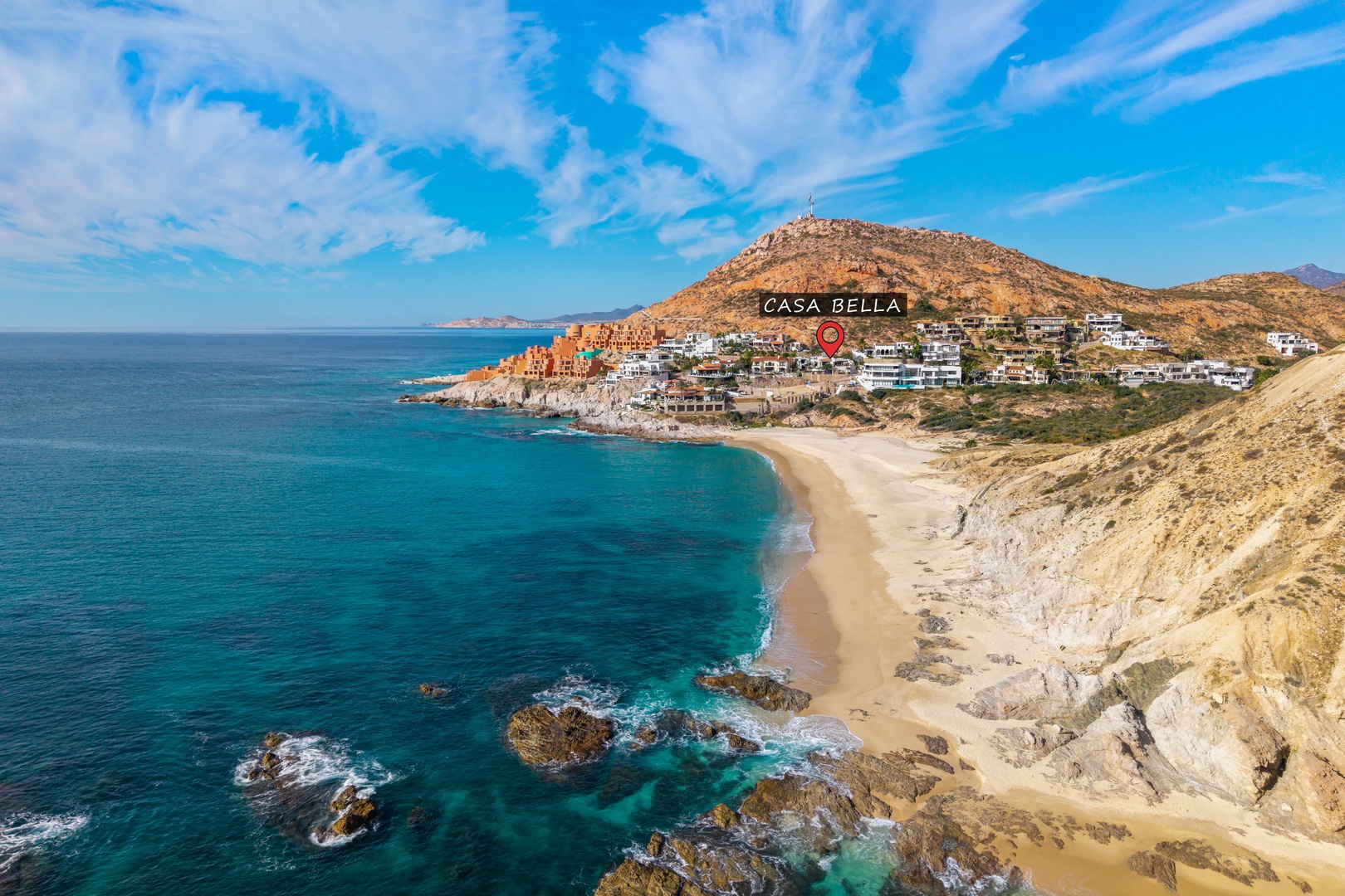 Stunning aerial view showcasing Casa Bella's prime location along this pristine coastal bay with turquoise waters and golden sand beach.