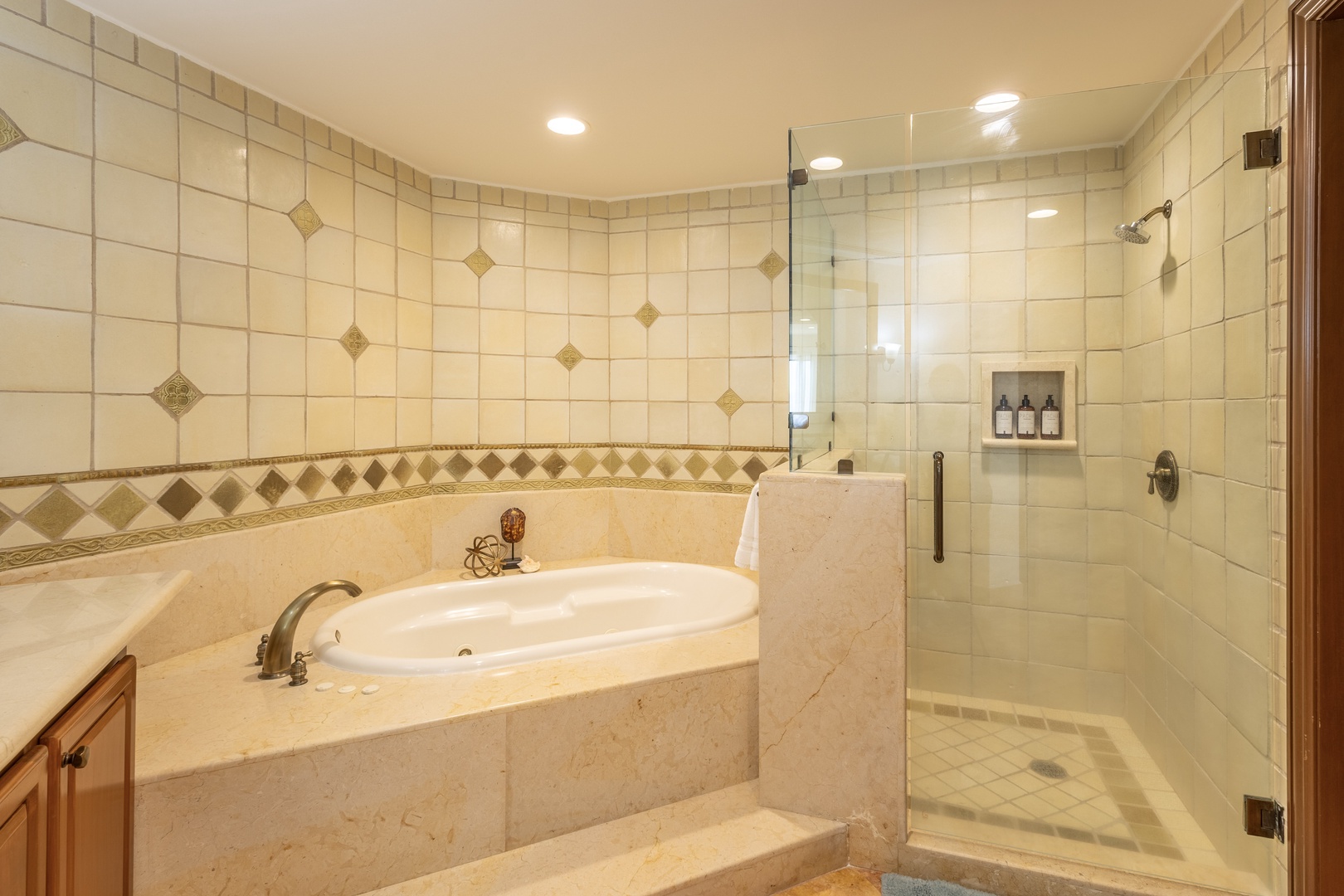 Unwind in your private spa-like bathroom featuring a luxurious soaking tub and spacious glass-enclosed shower with elegant tilework.