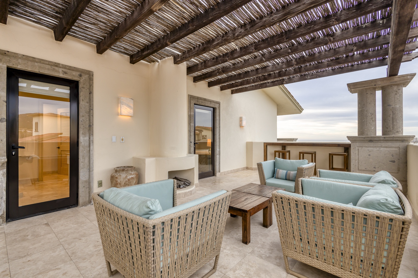 Sink into the soft wicker seating of your private terrace, where slatted shade meets open sky and a sauna awaits just steps away.