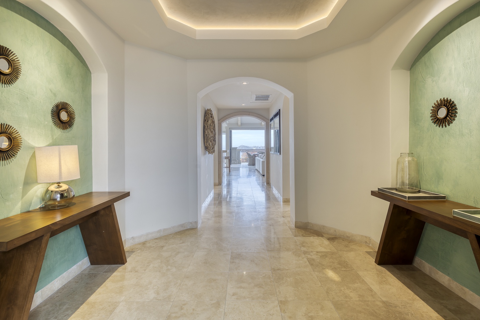 Step into elegance through this welcoming entryway, where polished marble floors and soft accent lighting guide you toward stunning ocean views. Thoughtful design and coastal-inspired touches set the tone for your retreat.