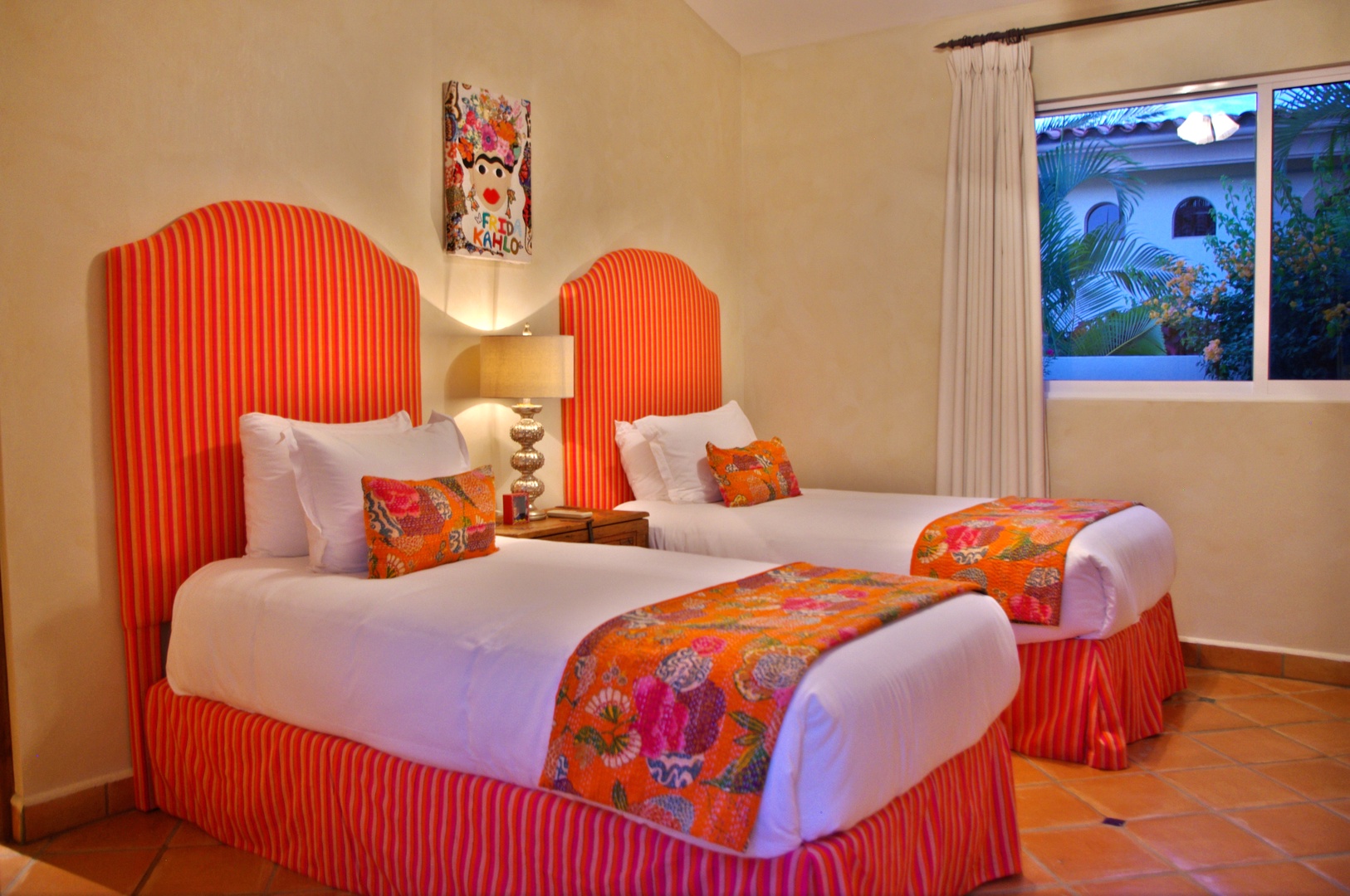 Sink into crisp white linens and vibrant tropical accents. Your twin beds invite restful sleep, while garden views and cheerful artwork create a warm, colorful retreat.