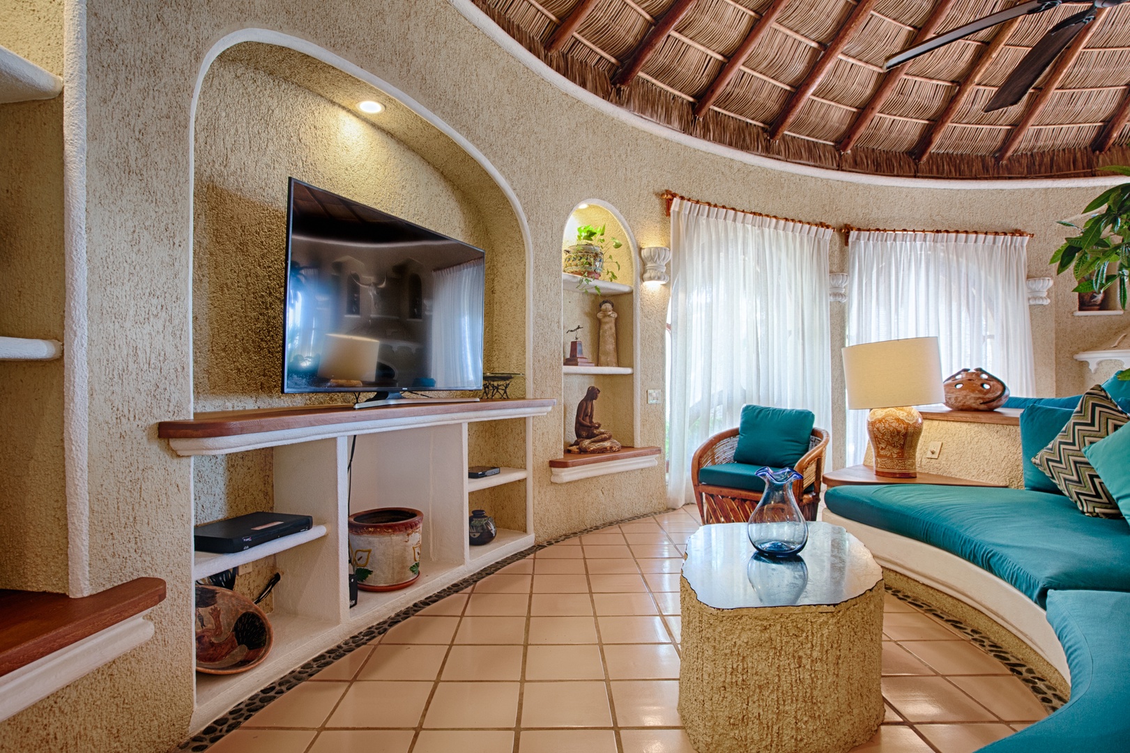 Unwind in your tropical living room where turquoise cushions, woven textures, and authentic Mexican details create perfect vacation vibes.