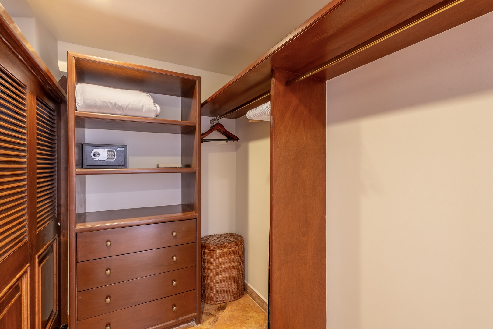 Your walk-in closet offers elegant wood storage with built-in drawers, shelving, and hanging space to keep your belongings organized.