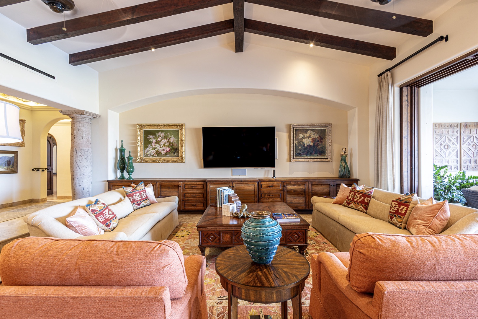 Sink into plush seating beneath dramatic exposed beams while you unwind with your favorite show or simply savor the warm, inviting glow of this beautifully appointed living space.