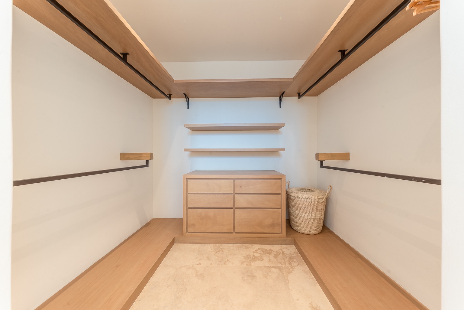Your private walk-in closet features custom wood shelving, a built-in dresser, and plenty of hanging space, keeping all your belongings neatly organized throughout your stay.