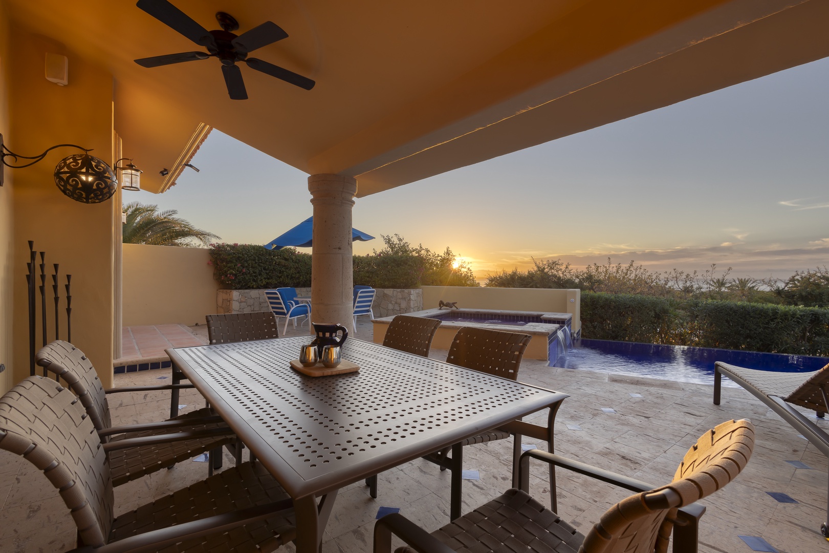 Your private patio invites sunset dining with elegant seating overlooking the sparkling pool.