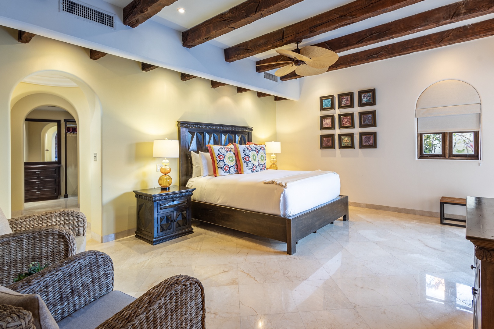Sink into plush bedding under rustic wooden beams in your serene retreat, where colorful accents and warm lamps create a cozy haven perfect for unwinding after a day of exploration.