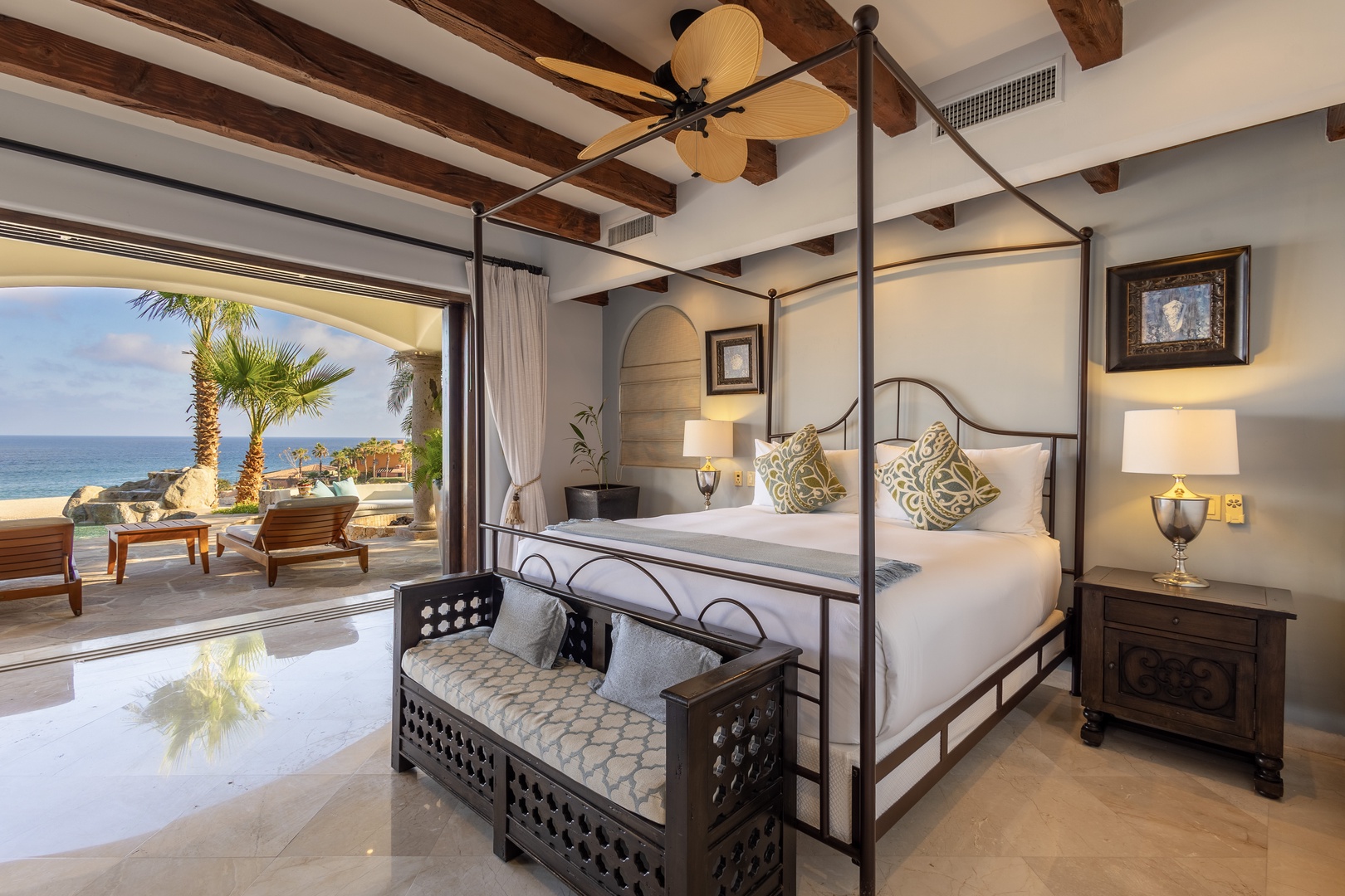 Wake up to breathtaking ocean views from your elegant four-poster bed. Tropical breezes drift through open doors leading to your private terrace, where palm trees frame the sparkling sea beyond.